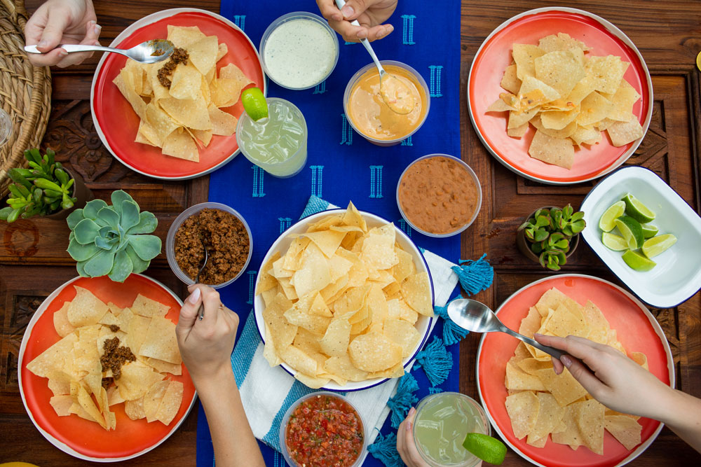 Chuy's server holding a big plate of several tortilla chips for catering.