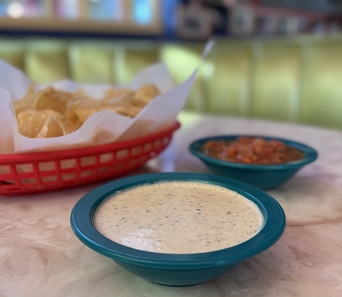Chuy's Creamy Jalapeno Dip next to chips and salsa.