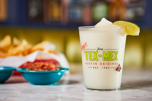 Chuy's Frozen Margarita served next to pico and chips.