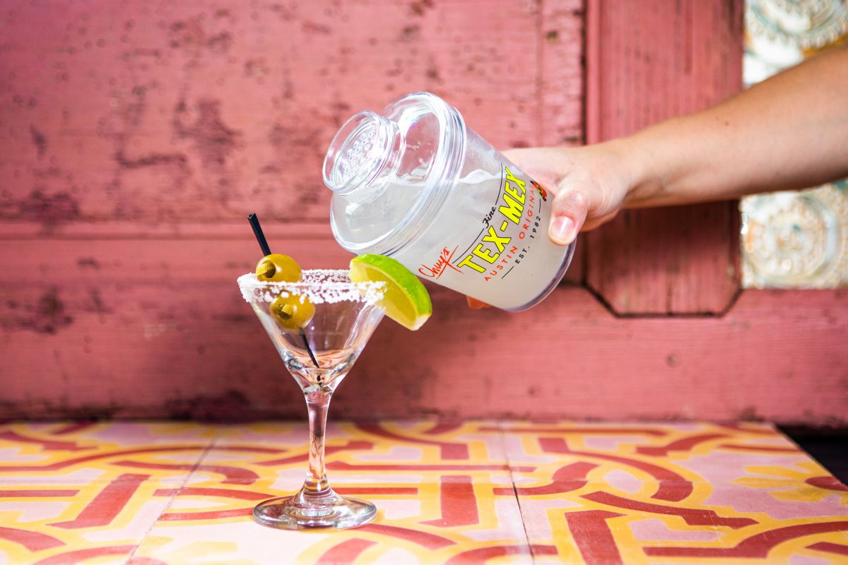 Chuy's Texas 'Tinis being served in a 18oz Shaker with a salt-rimmed martini glass and jalapeno-stuffed olives.