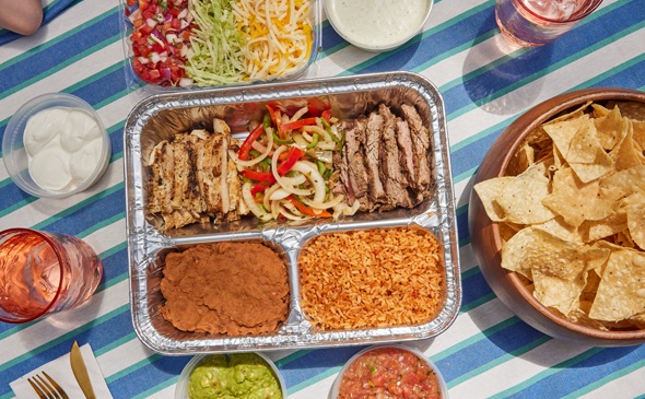 Chuy's Fajita Kit. Served next to drinks, sauce, and chips.
