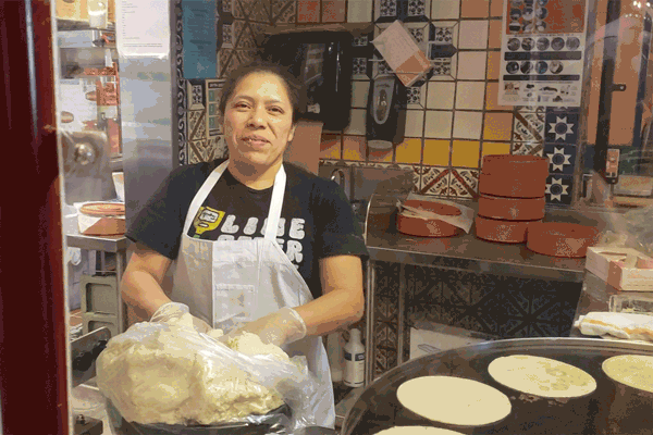 Chuy's worker handmaking and cooking tortillas.