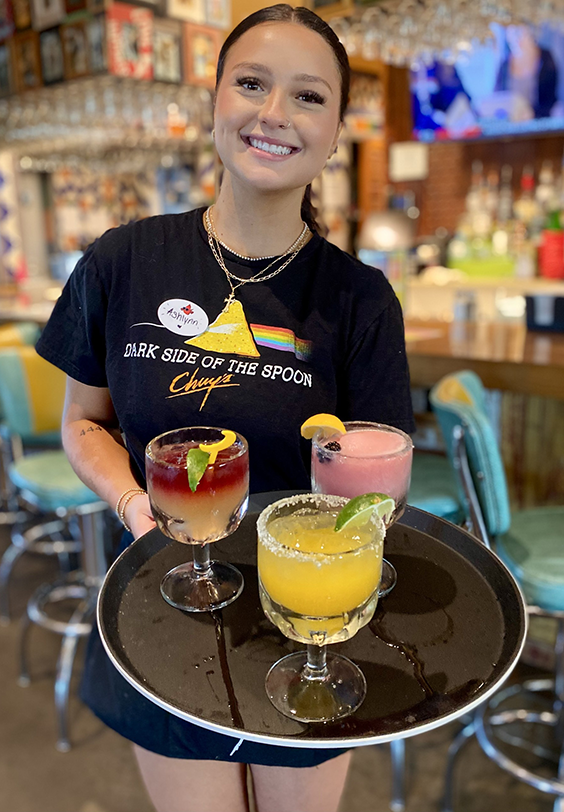 Chuy's server serving three margaritas.