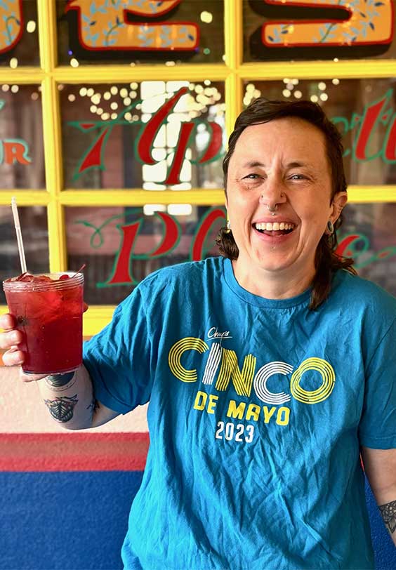 Chuy's bartender smiling serving up a Cinco de Mayo drink.