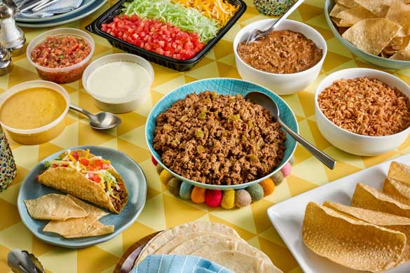 Chuy's National Taco Day taco feast with crispy tacos, chips, queso dip, salsa fresca, and taco fixings from Chuy's.