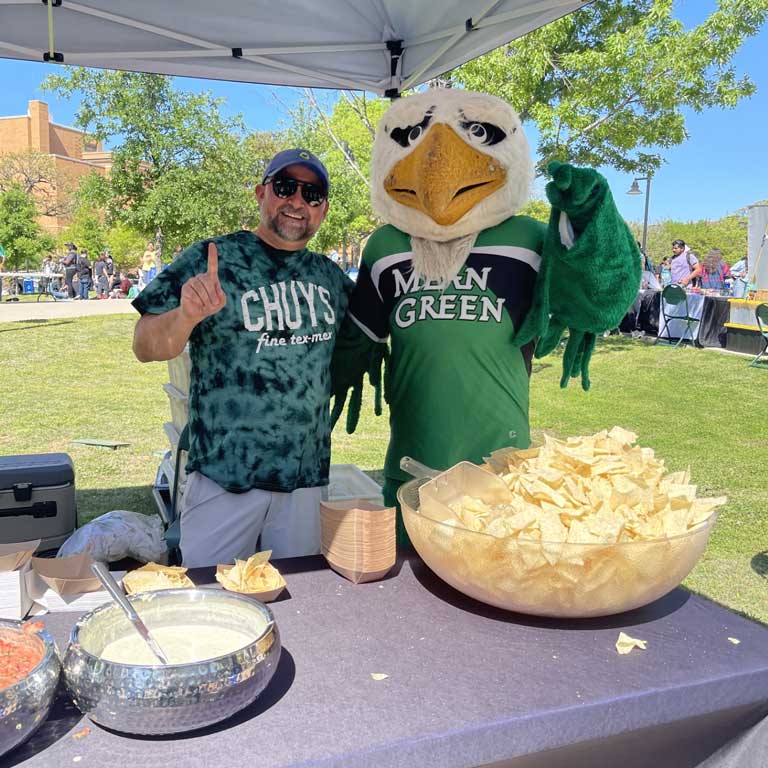 Tent featuring Chuy's food at a college, featuring the Mean Green Mascotte!