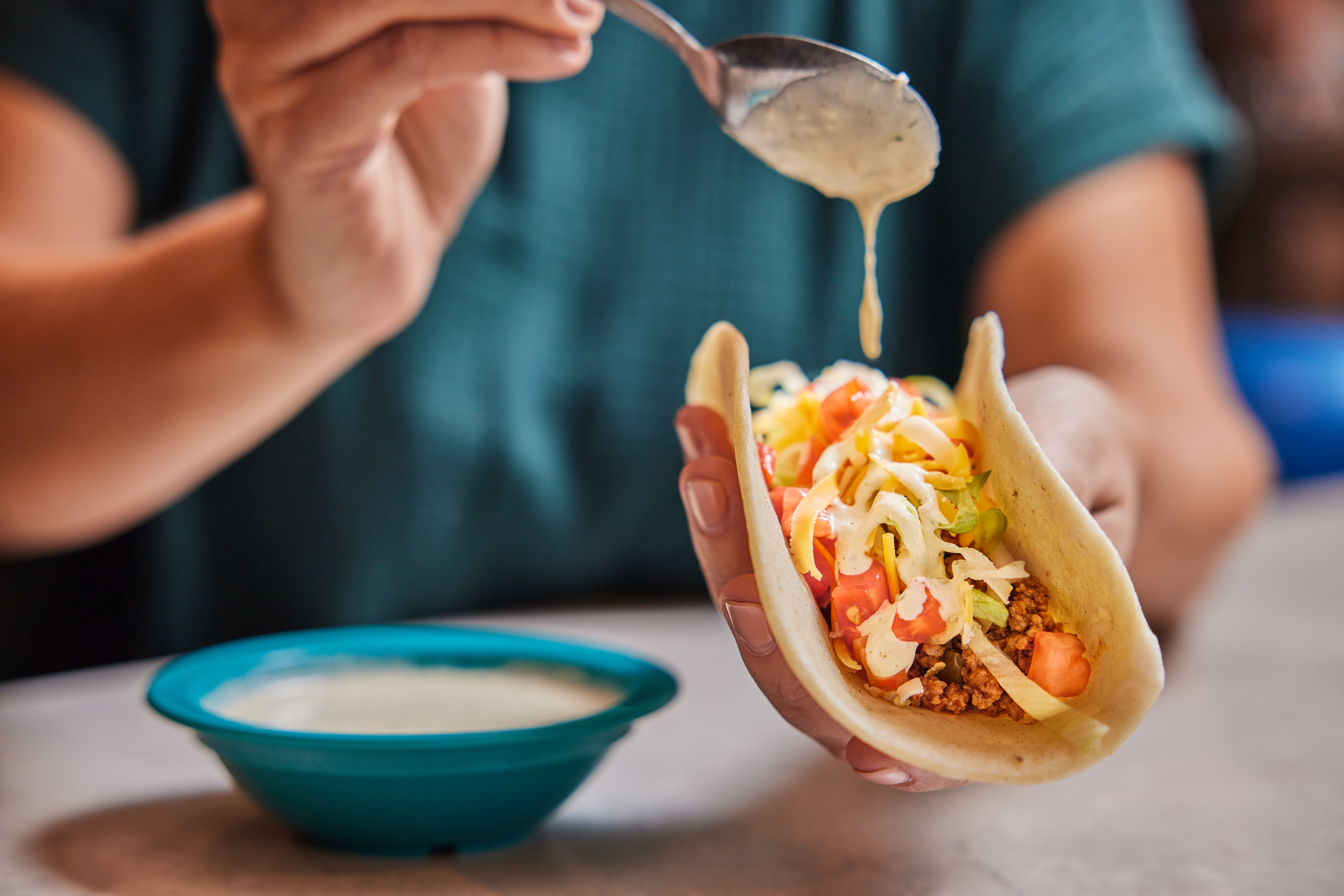Dipping some Chuy's Creamy Jalapeno Dip onto a taco.
